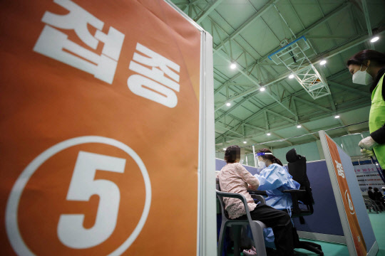 지난달 30일 오후 광주 북구 코로나19 예방접종센터에서 보건소 의료진이 75세 이상 어르신들에게 화이자 백신 접종을 하고 있다. 연합뉴스